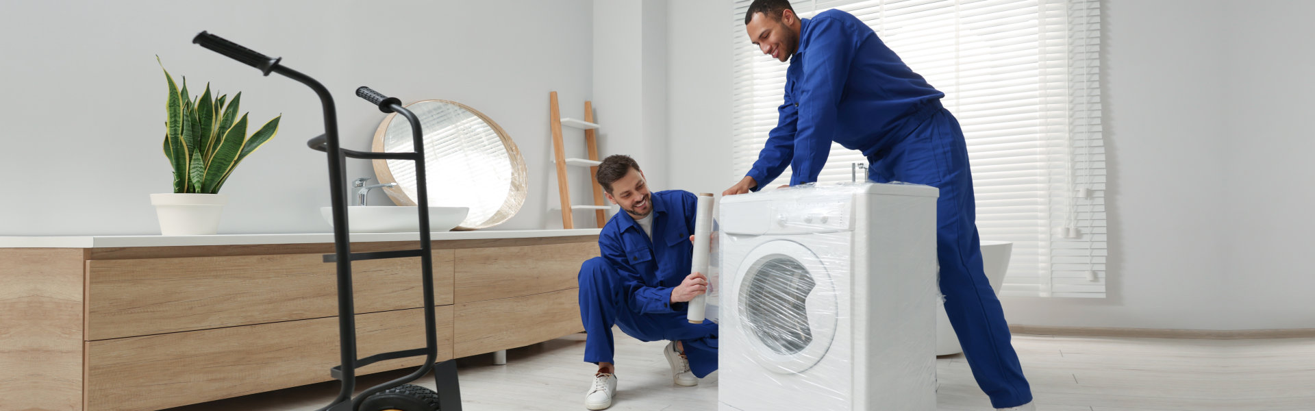 two men wrapping a washing machine